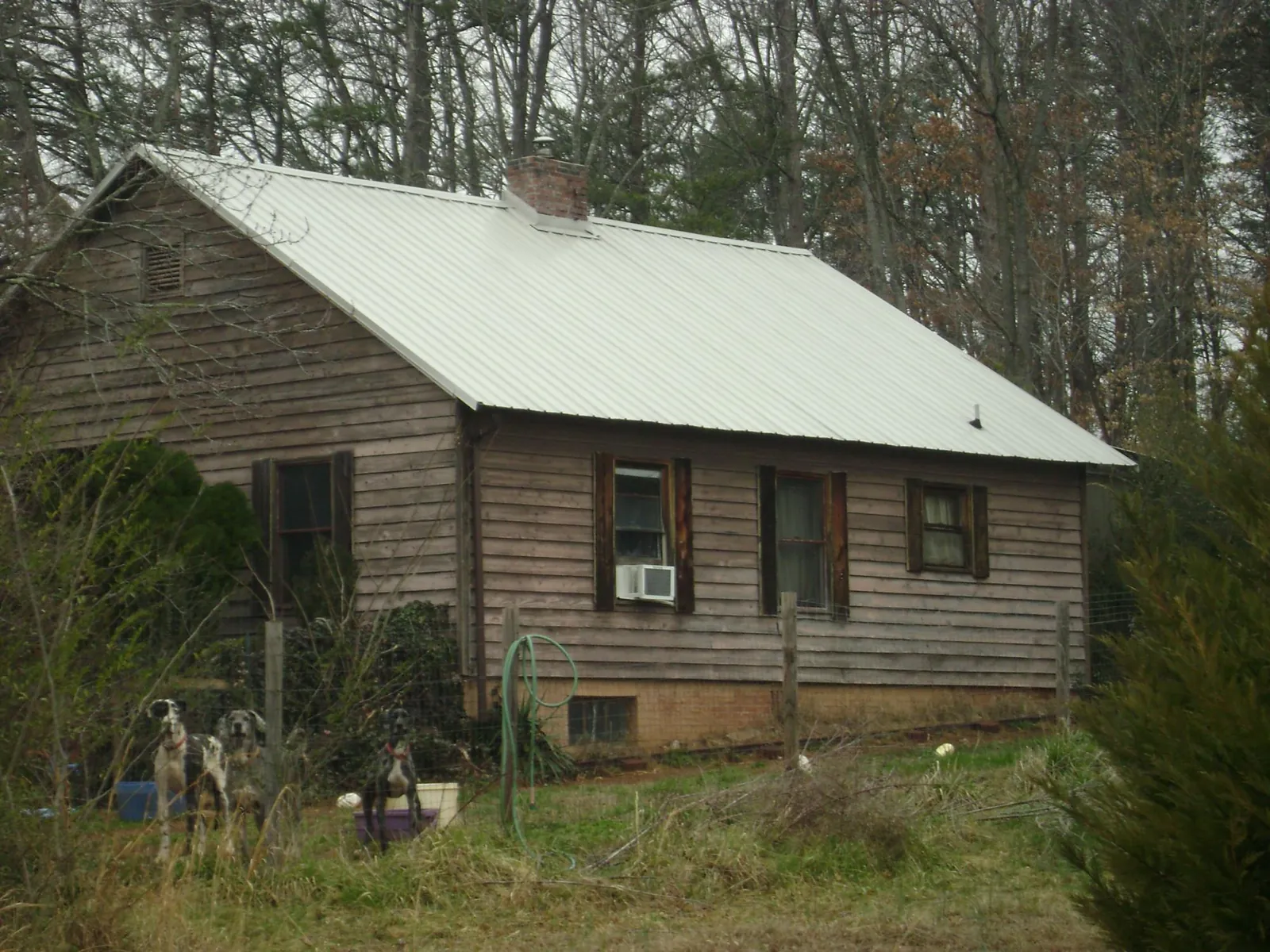 White metal roof on an old wood sided farmhouse, from a Asphalt Shingle Roof Repair job in Alexandria